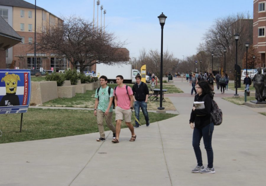 Students walk across campus before it closed for the semester because of COVID-19. Campus, county, and state officials warn that the population of 20 to 44-year-olds are at higher risk for catching and spreading the virus than they may think.
