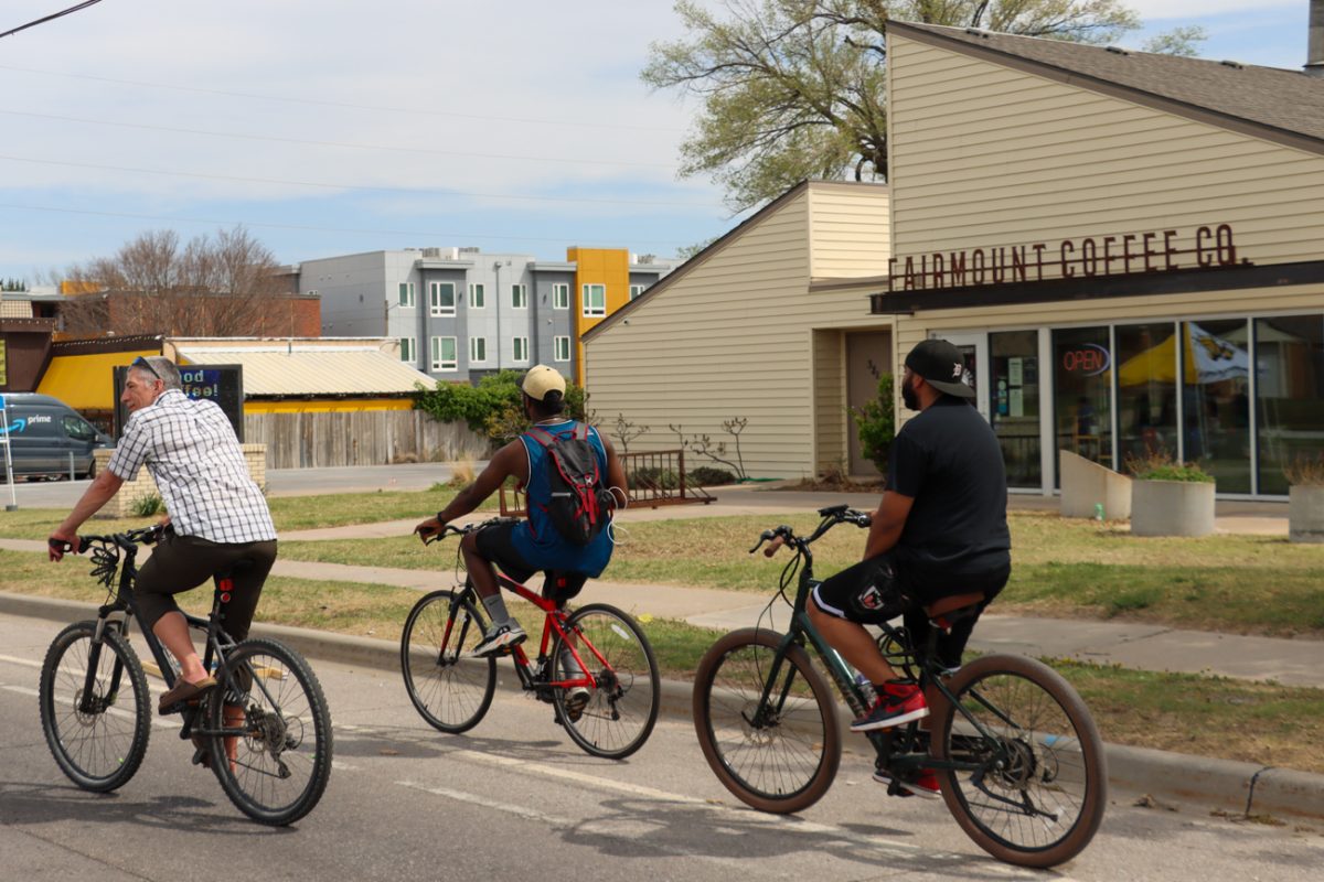A trio of cyclists slip through a part in the crowd in front of Fairmount Coffee Co. Alongside visiting vendors for the event, many 17th Street businesses had their doors open to Open Streets passersby.